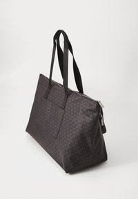 Sac fourre-tout en tissu sombre avec un motif géométrique, doté de deux poignées robustes, d'une fermeture éclair et d'une poche avant pour plus de commodité.