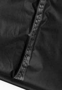 Tissu noir imperméable avec une texture lisse, présentant un détail de couture le long d'un bord. Dans l'ensemble, un design épuré et minimaliste.