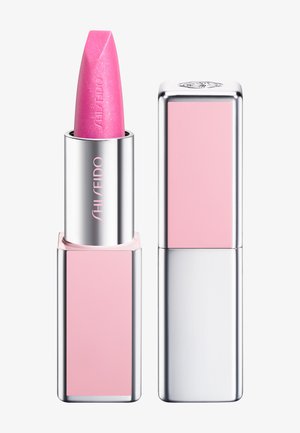Roze lippenstift met zilveren en roze rechthoekige verpakking, merknaam Shiseido op de tube met dop ernaast geplaatst.