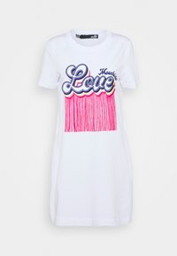 Witte katoenen t-shirt jurk met "Love" in kleurrijke letters en roze franjes. Korte mouwen en een ronde hals.