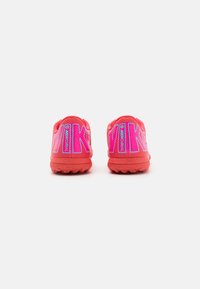 Pantofi sport roșii cu un superior sintetic texturat, cu un branding mare „Nike Mercurial” în roz și albastru pe toc. Talpă din cauciuc.