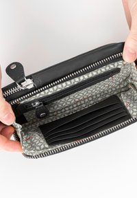 Schwarze Lederbörse mit silbernen Beschlägen; das Innere verfügt über ein hellgraues gemustertes Futter und mehrere Kartenfächer. Sichtbarer Reißverschluss.