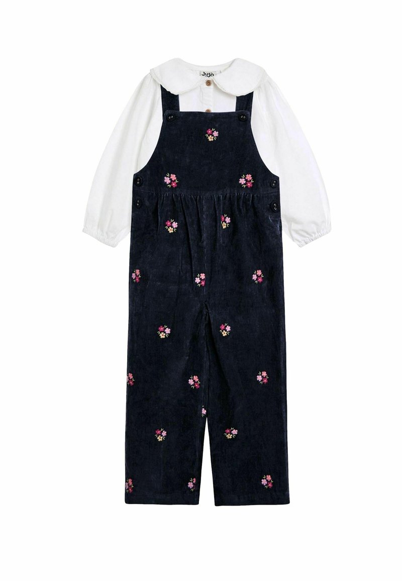 Navy Corduroy-Latzhose mit pinkfarbener Blumenstickerei, mit Schulterträgern, einer Knopfleiste und einem weißen Langarmshirt darunter.