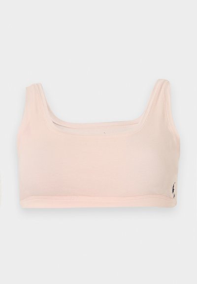 Αθλητικό μπουστάκι από απαλό ύφασμα σε ανοιχτό ροζ χρώμα, με φαρδιές τιράντες ώμων και μικρό σκούρο λογότυπο στο κάτω δεξιό μέρος.