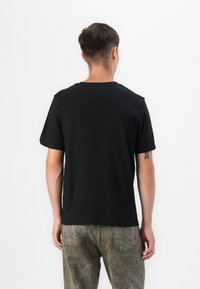 Black short-sleeve T-shirt made of cotton with a crew neckline. Features a simple design with no visible patterns or accents.
