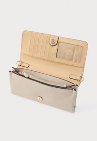 Bézs bőrpénztárca texturált külsővel, több kártyatartóval, átlátszó személyi igazolvány ablakkal és aranyszínű fém kiegészítőkkel ellátott cipzáras rekesszel.