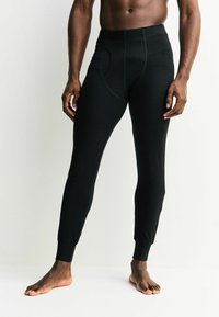 Čierne elastické legíny s priliehavým strihom, elastickým pásom a manžetami na členkoch, s hladkou textúrou a detailom bočného vrecka.