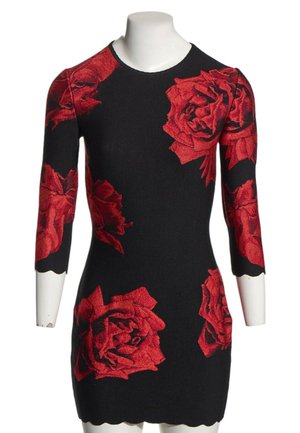 Robe noire cintrée avec de grands motifs de roses rouges et des manches trois-quarts, affichée sur un buste de mannequin blanc.