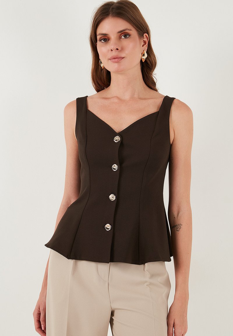 Škrtast top v rjavi barvi brez rokavov z obliko V-izreza, šestimi srebrnimi gumbi po sprednji strani in razširjenim peplum robom. Gladka tekstura tkanine.