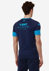 Camisa atlética azul marino con mangas cortas en color teal, presenta el logo "BWT ALPINE F1 TEAM" impreso en la parte de atrás, fabricada con un material transpirable.