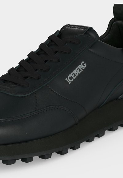 Baskets en cuir noir avec lacets noirs, semelle à crampons épaisse et logo blanc "ICEBERG" sur le panneau latéral.
