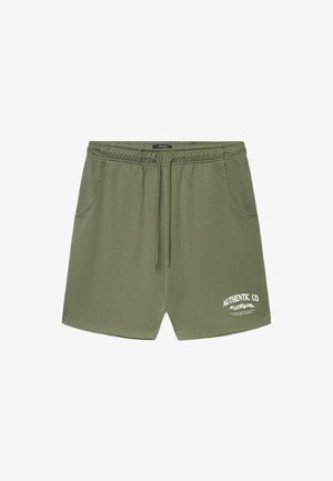Pantaloncini in cotone verde oliva con cintura elastica e coulisse. Presentano due tasche laterali e dettaglio logo stampato bianco sul davanti.