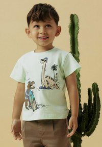 Kurzärmliges T-Shirt in Mintgrün mit Cartoon-Dinosauriern, Palmen und einem Surfbrett-Motiv. Aus Baumwollstoff, entspannte Passform.