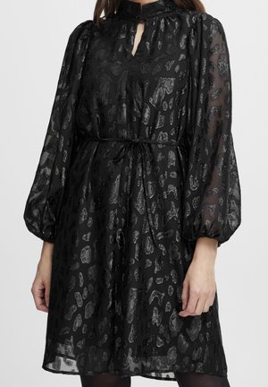 Sort gennemsigtig midi-kjole med skinnende leopardpletter, ballonærmer, høj hals med nøglehul og bundet bælte i taljen.