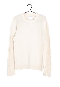 Off-white stickad tröja med ett strukturerat mönster, rund halsringning och ribbade mudd- och nederkanter. Hänger från en svart krok.