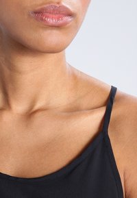 Czarny top na ramiączkach z cienkimi paskami, charakteryzujący się miękką, gładką fakturą oraz okrągłym dekoltem, który podkreśla obojczyki.