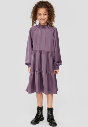 Robe violette à manches longues avec un col froncé et un design à niveaux. Associée à des bottes noires à lacets pour un look contrastant.