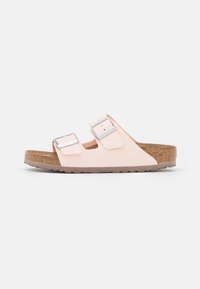 Sandali rosa con due cinturini regolabili, fibbie argentate, soletta in sughero e suola in gomma texturizzata. Design semplice e aperto per il massimo comfort.