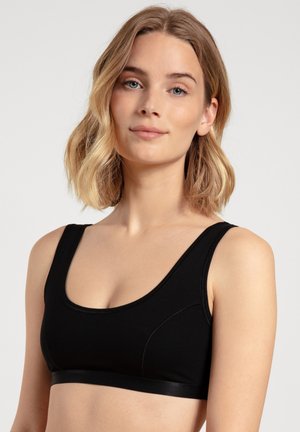Zwarte sportbeha met een ronde hals, zachte stof en een gladde, elastische band aan de onderkant. Bevat minimale naden en heeft een slank ontwerp.