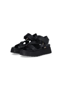 Black platform sandals with wide straps, made of leather, featuring a thick textured sole and a simple metallic accent.