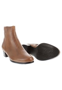 Botines de cuero marrón con punta afilada, paneles laterales elásticos y un tacón bajo tipo bloque. La suela presenta un diseño texturizado y con patrón.