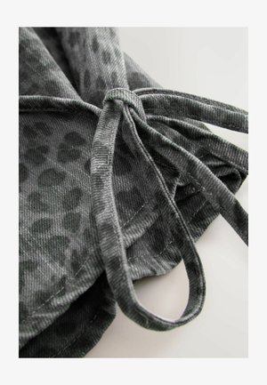 Grått tyg med en mjuk textur och en subtil leopardmönstring. Inkluderar en knytstängning med tygöglor och synliga sömnadsdetaljer.