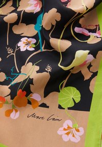 Écharpe en soie présentant un motif floral dans des tons de rose, orange et vert sur fond noir, avec une bordure verte et une signature.