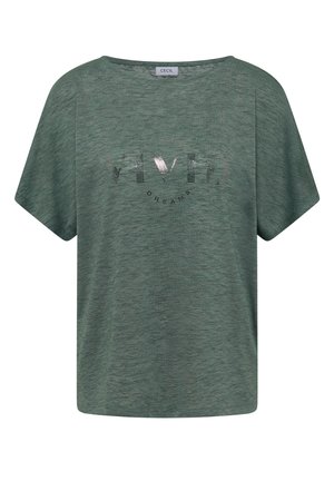 Zielona koszulka z krótkim rękawem i okrągłym dekoltem, z metką "CECIL" oraz błyszczącymi literami tworzącymi napis "VIBE" z "DREAMS" pod spodem na przedzie.