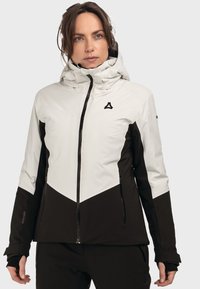 Damen wasserdichte Jacke mit einem Design aus Schwarz und Weiß, hohem Kragen und Reißverschlusstaschen. Glattes Material mit ergonomischer Passform.