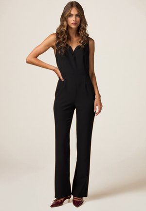 Zwart mouwloos jumpsuit met een v-hals, getailleerde pasvorm en rechte pijpen. Gladde stoftextuur met een minimalistisch design.