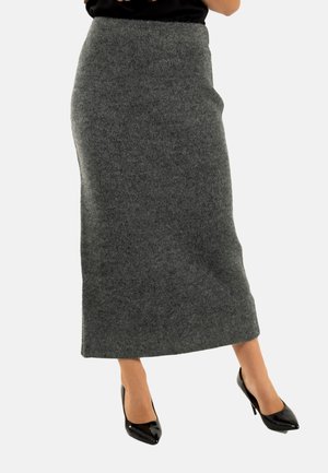 Jupe maxi en laine grise avec une taille ajustée, texture lisse et silhouette droite, associée à des escarpins noirs à bout pointu.