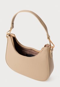 Sac à main en forme de croissant beige avec une fermeture éclair et des fermoirs dorés, une seule sangle et le dessus partiellement ouvert montrant un intérieur en tissu noir.
