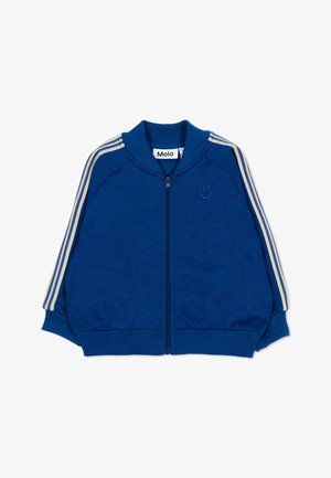 Blauwe jas met rits, crèmekleurige strepen op de mouwen, geribde boorden en een klein geborduurd smiley-gezicht op de borst.