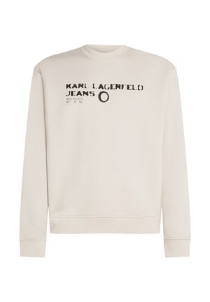Light beige sweatshirt featuring a round neckline, long sleeves, and printed text. Material appears soft and cotton-like with ribbed cuffs.