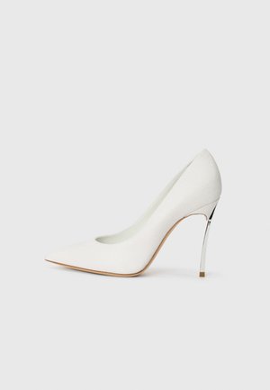 Pumps albe cu toc înalt, cu vârful ascuțit, acoperite cu o textură fină de sclipici. Accentul metalic argintiu al tocului adaugă contrast. Design elegant.