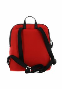 Sac à dos rouge en matériau lisse et durable. Présente des bretelles noires, deux poignées supérieures et une fermeture éclair en haut. Design minimaliste.