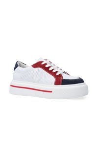 Weißer Sneaker mit roten und navy-blauen Akzenten. Perforierte Seiten, weiße Schnürsenkel und eine strukturierte Sohle mit einem roten Streifen. Legeres flaches Design.