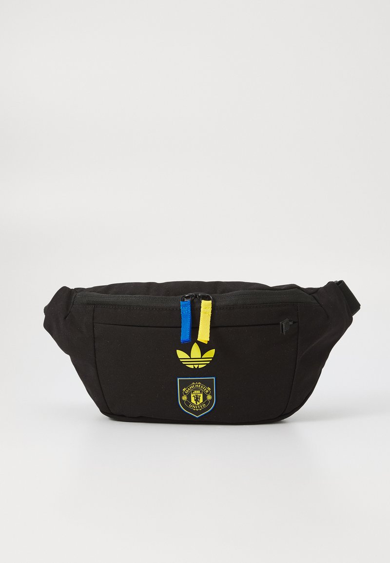 Black fanny pack with a front zip pocket, featuring blue and yellow zipper pulls, a yellow Adidas logo, and a Manchester United emblem.