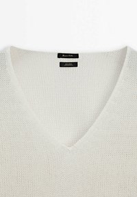 Lekki biały sweter z lnu z dekoltem w kształcie litery V, teksturowanym wzorem dzianiny oraz podwójnymi metkami na dekolcie.