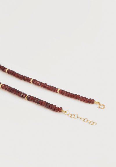 Κολιέ με σκαλιστές σκούρες κόκκινες χάντρες και μικρές χρυσές χάντρες διαχωρισμού, με χρυσό κούμπωμα σε σχήμα αστακού και ρυθμιζόμενο επιμηκυντή αλυσίδας.