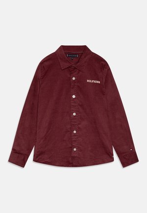 Rødbrun kordfløjls skjorte med lange ærmer, knapper foran, krave, "Hilfiger" broderet på brystet og et lille logo på manchetterne.