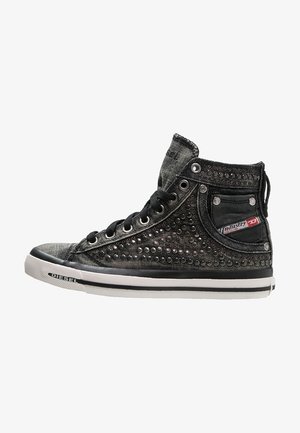Czarny sneaker za kostkę z metalowymi ćwiekami, czarnymi sznurowadłami, białą podeszwą i małą boczną kieszonką oznaczoną "Industry Division."