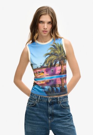 Top sin mangas que presenta un gráfico vibrante de palmeras y un edificio rosa contra un cielo azul, hecho de una suave tela elástica.