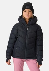Giacca piumino nera con cappuccio, caratterizzata da un design trapuntato, chiusura con zip e polsini elasticizzati, abbinata a pantaloni rosa.