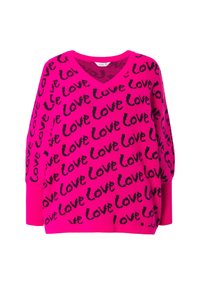Magenta oversized svetr s výstřihem do V, který má opakující se černý vzor s textem "Love". Rybáři na manžetách a lemu dodávají texturu.