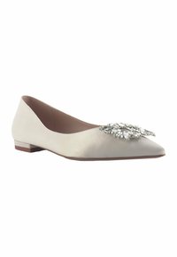 Chaussure plate en satin blanc avec un design à bout pointu, ornée d'un détail de broche bijou à l'avant et d'un petit talon marron.
