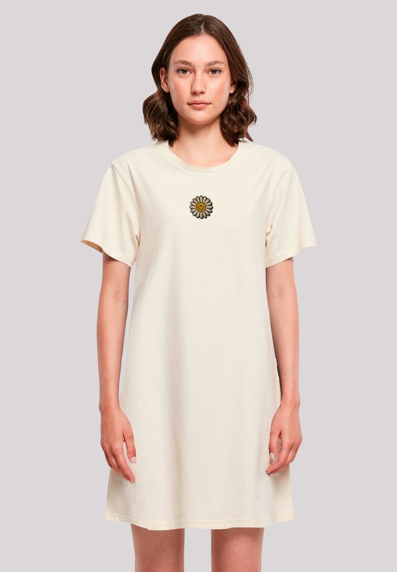 Crème-kleurige katoenen t-shirt jurk met korte mouwen en een ronde hals, voorzien van een geborduurd madeliefje op de borst.