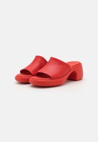 Mules vermelhos de plataforma com um design de ponta aberta. Feitos de material suave, apresentando um salto bloco arredondado e sola texturizada para maior aderência.