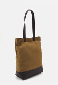 Leinene Tragetasche in Braun mit einem dunkelbraunen Lederboden. Verfügt über lange, robuste Griffe und ein einfaches, ungeschmücktes Design.
