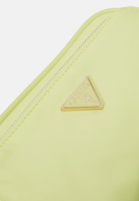 Borsa a tracolla gialla neon con finitura texture, dotata di una placca con logo triangolare in oro e chiusura a cerniera lungo il bordo.